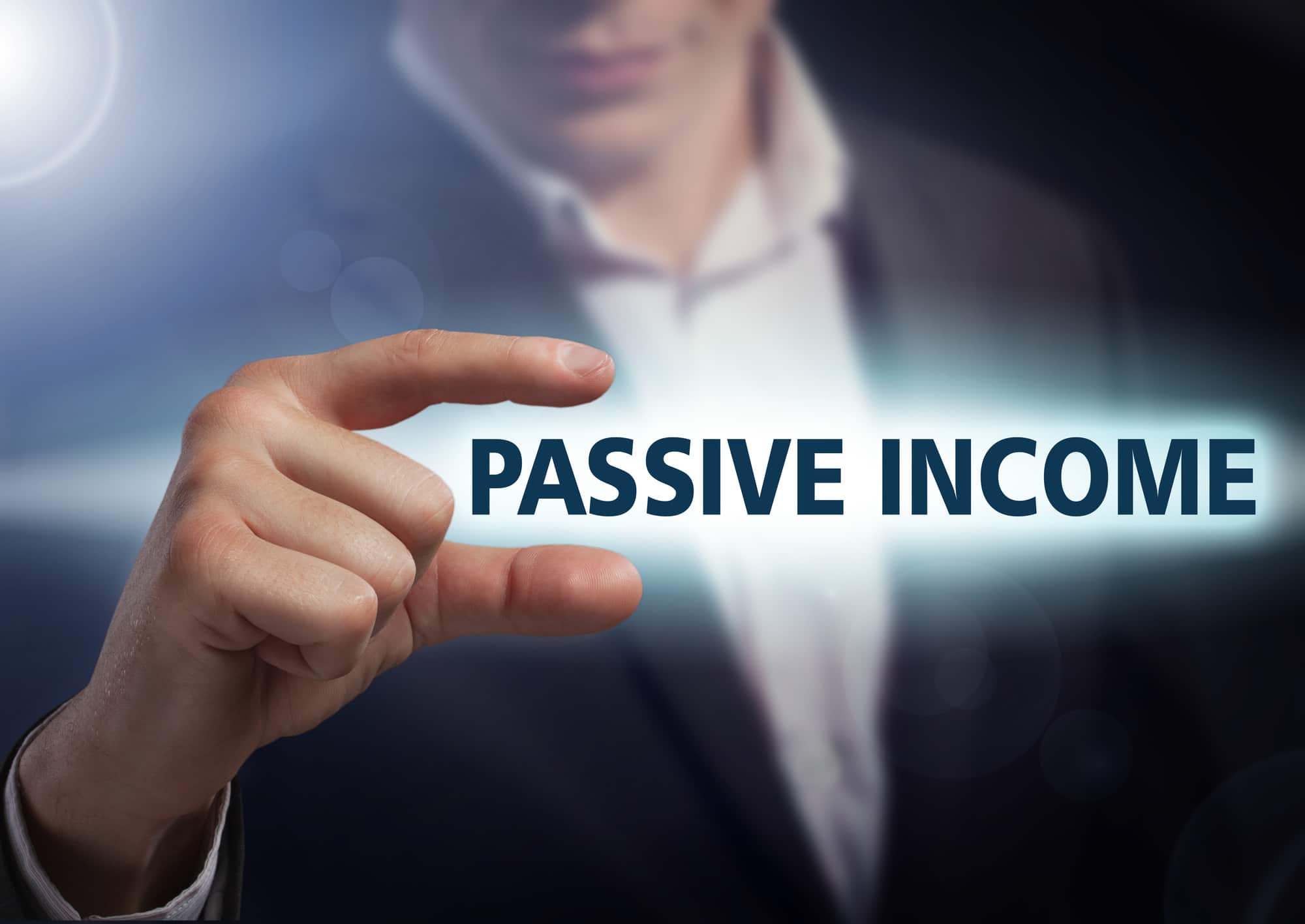 Businessman presses button passive income on virtual screens. Bu